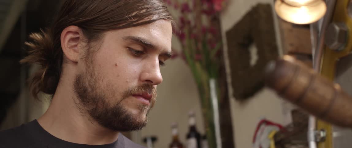 A long-haired brunette man working