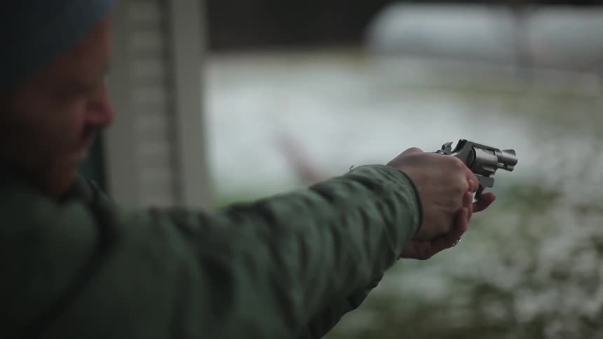 Man fires a silver pistol