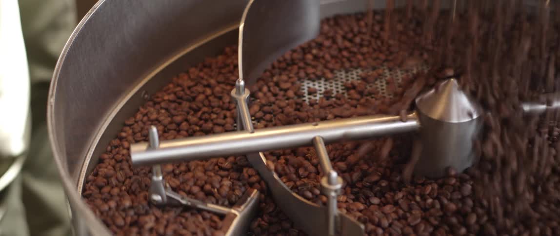 A large amount of coffee beans poured into an empty machine