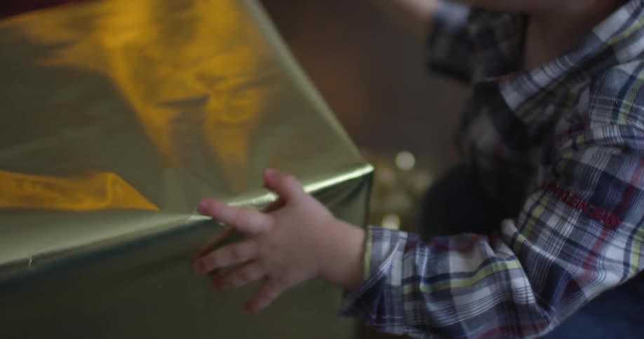 A boy sits down with a christmas gift