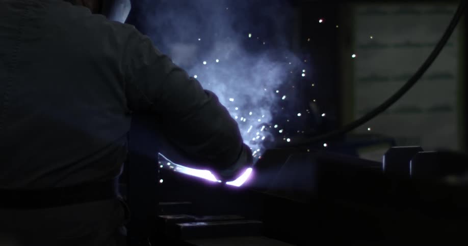 A welder creates sparks and smoke