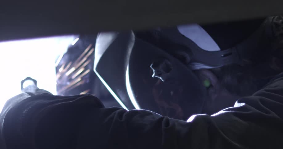 Man with earplugs and face mask welds