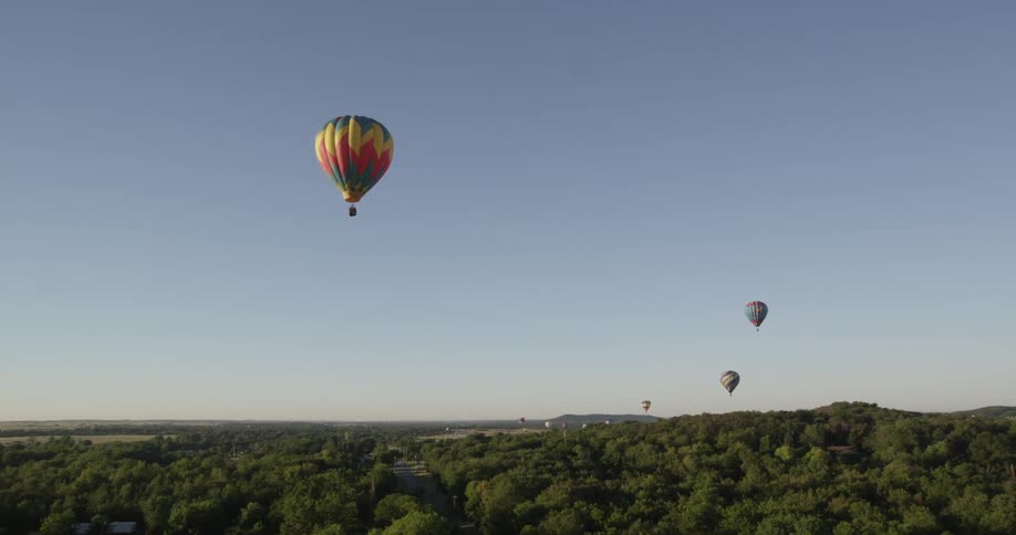 Hot air balloons flying over a forest
