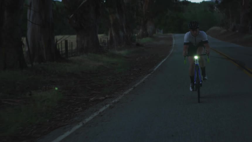 Man bikes down a dark road
