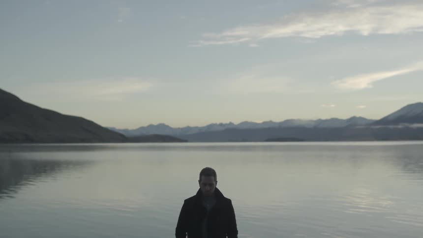Man stands in front of a lake