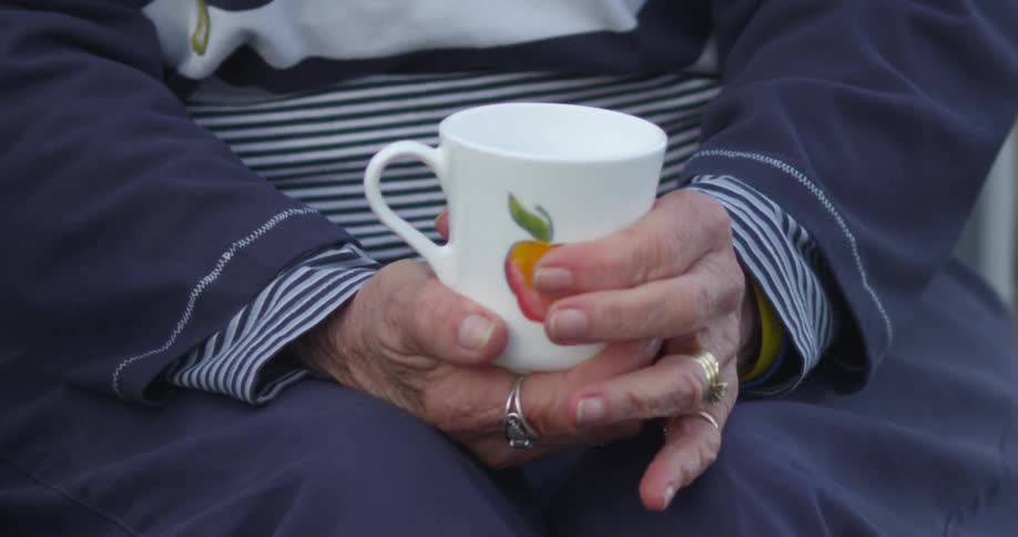 A woman holds and rotates a mug