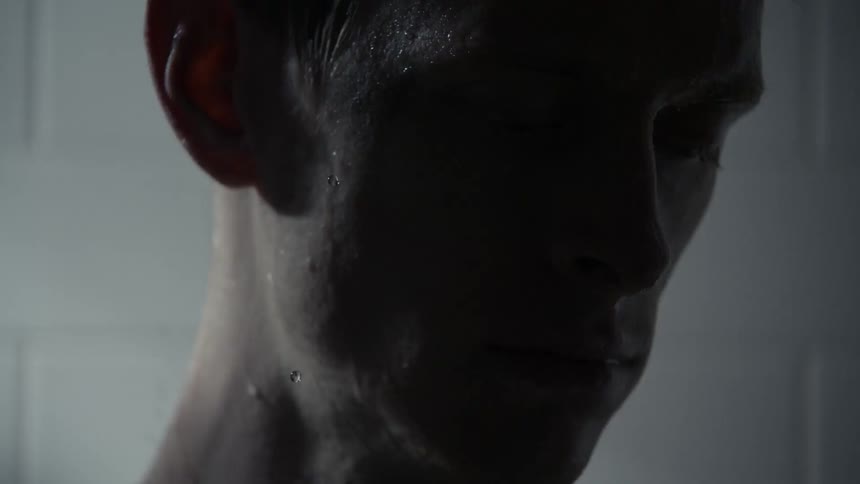 A water covered man under a strobe light