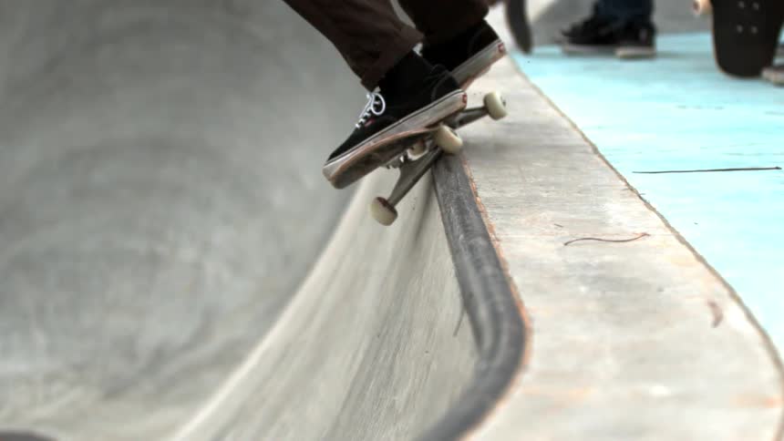 A skateboarder grinding along the top of a halfpipe