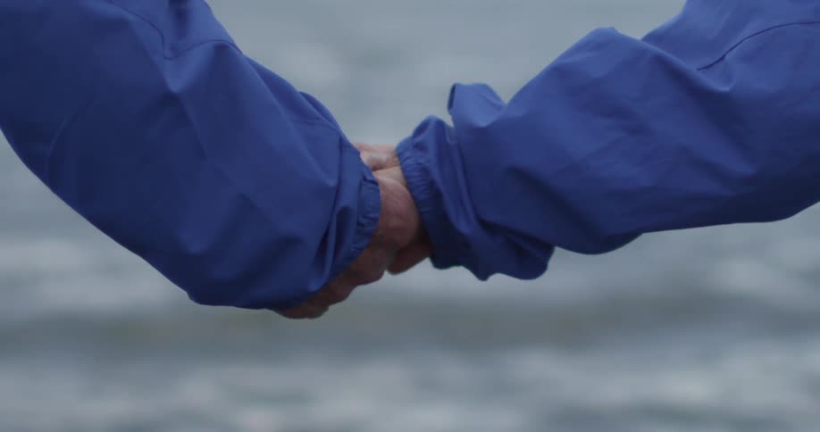 A couple taking hold of each other's hand, then letting go