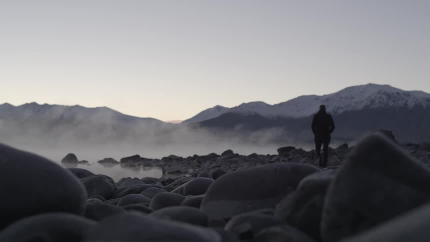 A person walking on  a rocky coast
