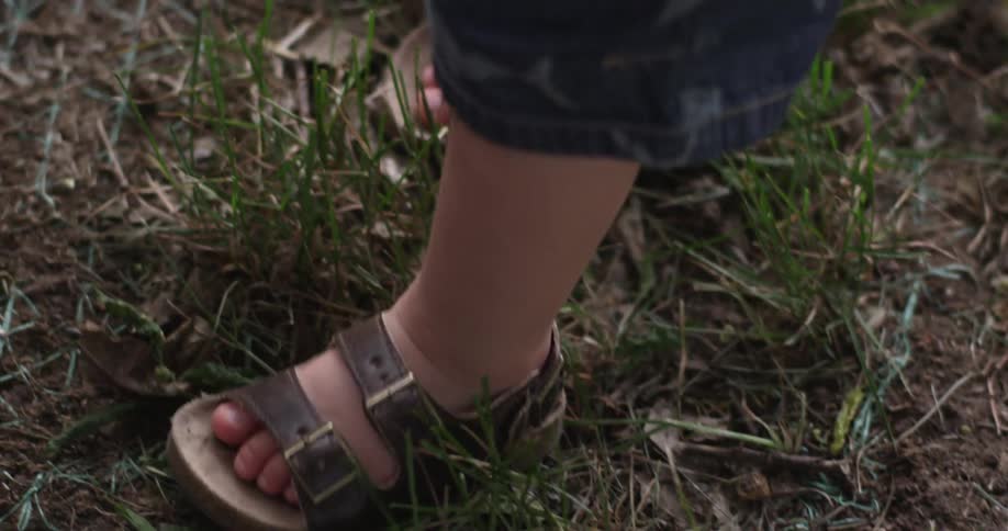 A toddler walking and exploring outside