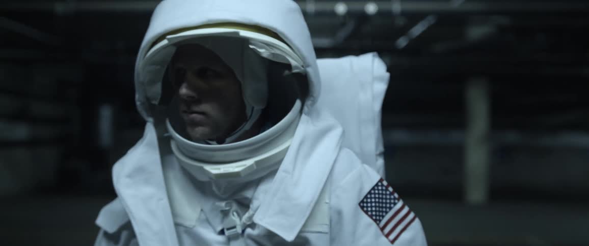 A person in an astronaut costume wandering an empty urban area at night