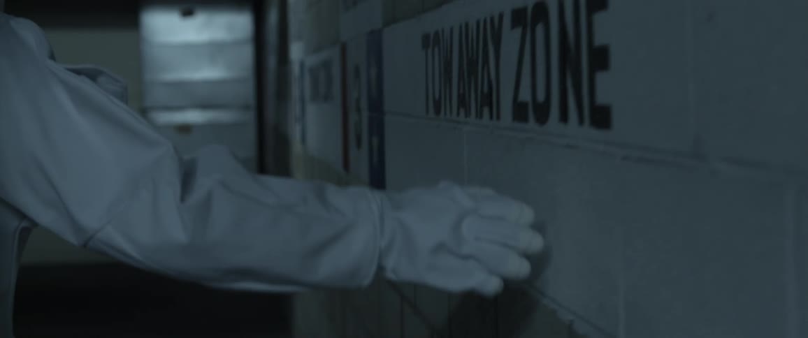 Person in a while suit, with white gloves touches the wall