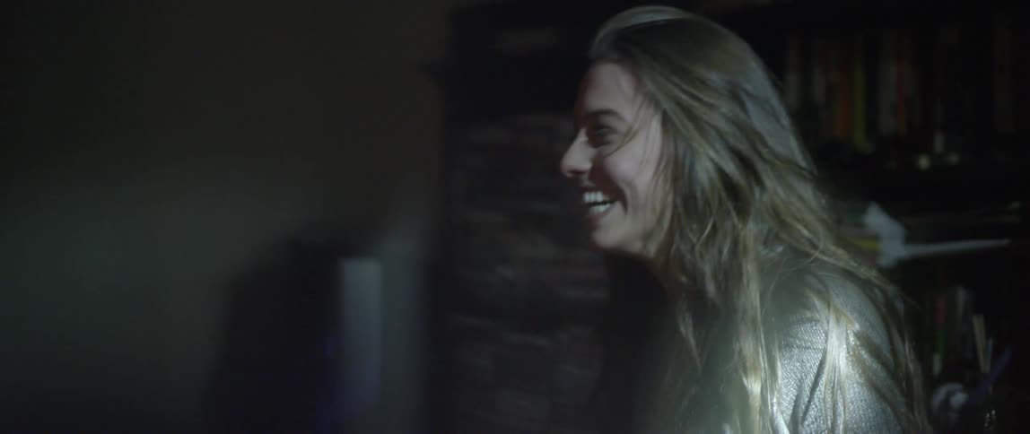 Man and woman laughing under a flashing light