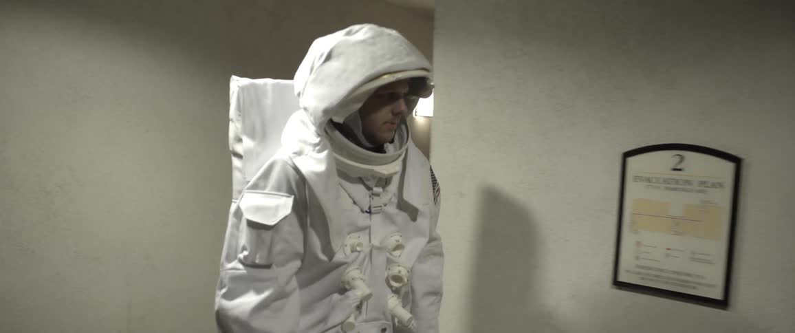 A person in an astronaut costume walking down a hallway
