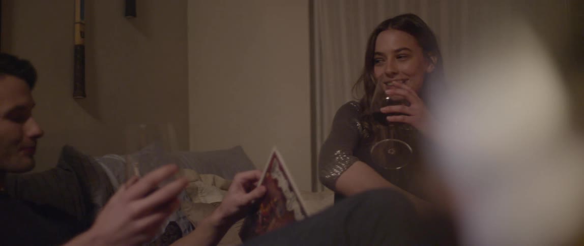 A woman and a man in a living room drinking wine and enjoying themselves