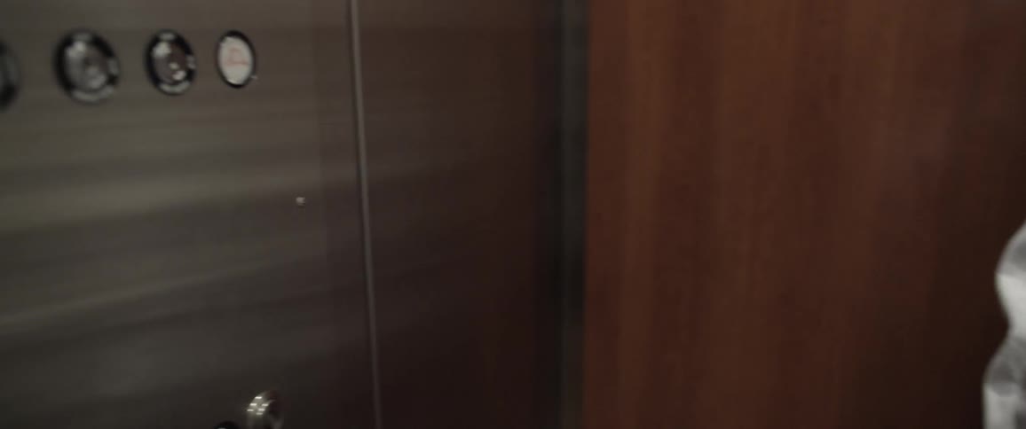 An astronaut walks into an elevator and pushes a button