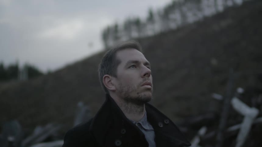 A man with furrowed brows looking up into the distance before closing his eyes