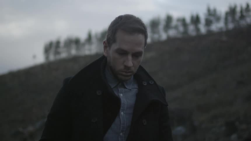 A person walking past a hillside