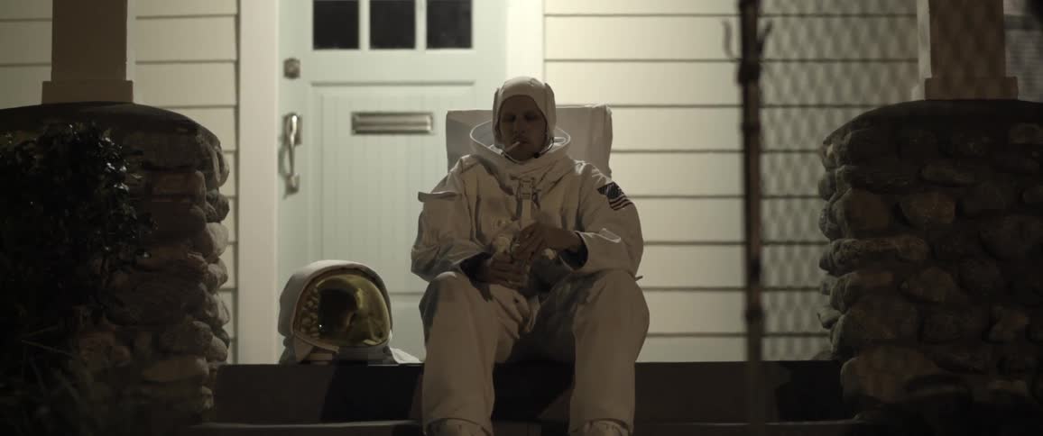 Astronaut smokes a cigarette on front porch