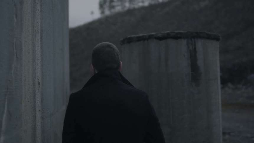A man walking next to an old barn
