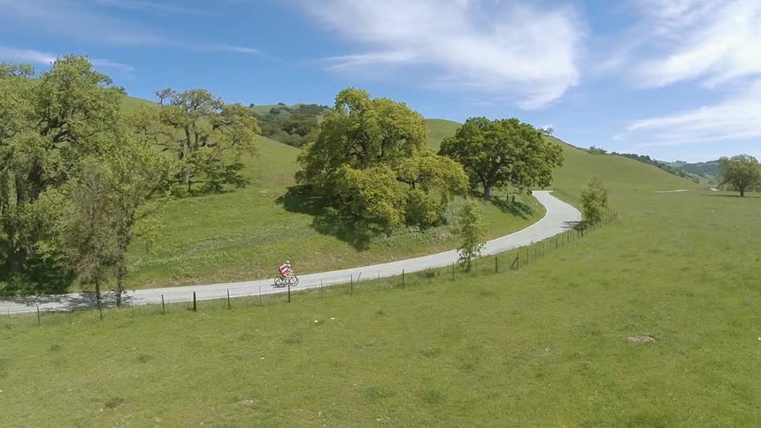 Man bikes down a twisting road