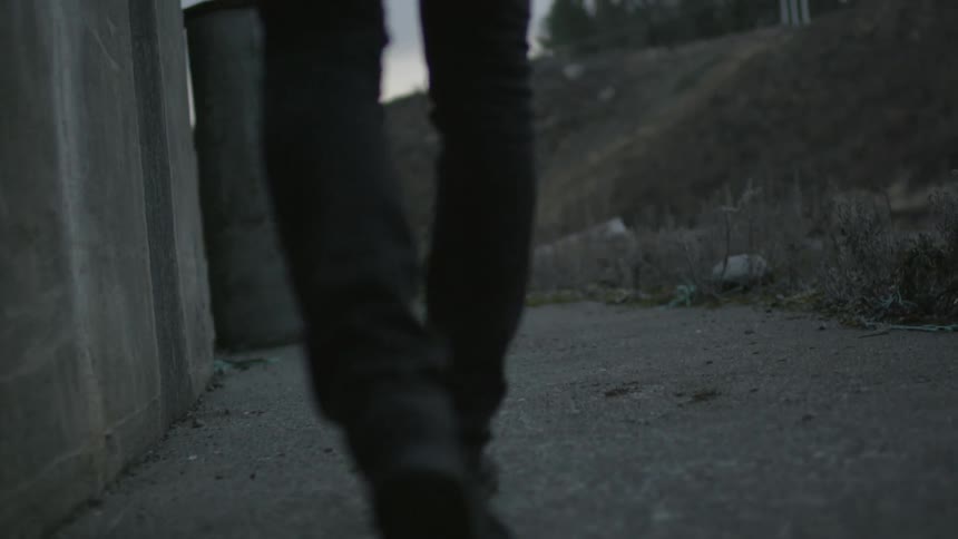 Man walking across concrete during the day