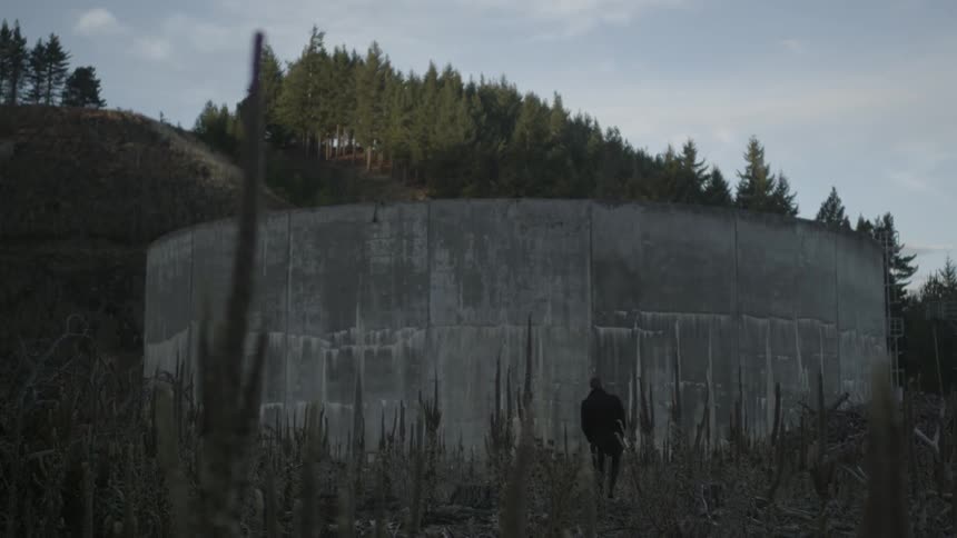 A person standing next to a large wall