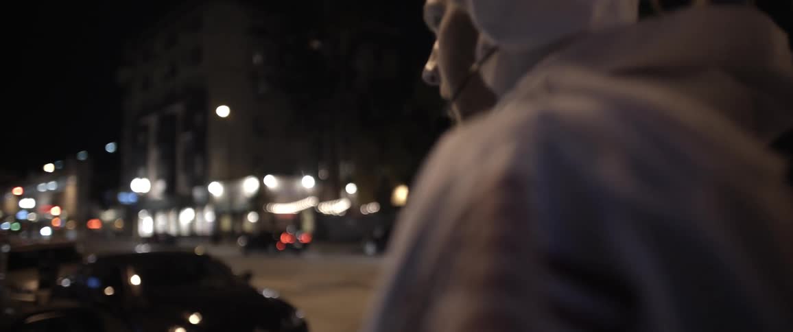 A man dressed as an astronaut walking down a busy urban street