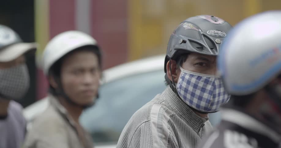 Men on motorized bicycles are stopped in traffic