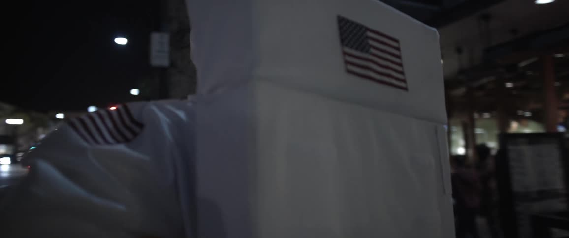An astronaut taking off their helmet