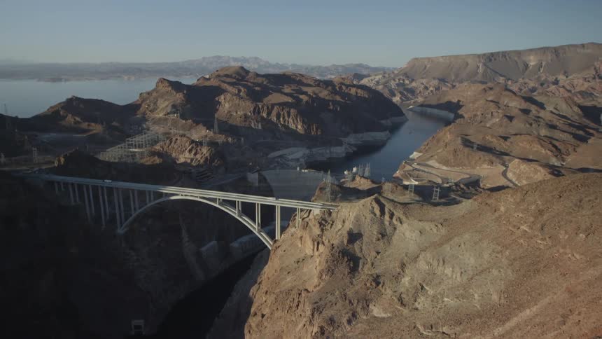 A long bridge connecting two mountains spans over a river