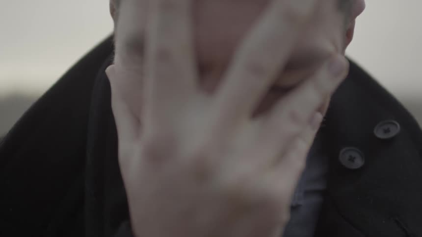 A man has his hand over his face