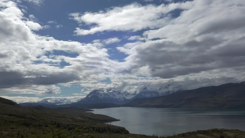 Clouds move slowly over a lake in a valley