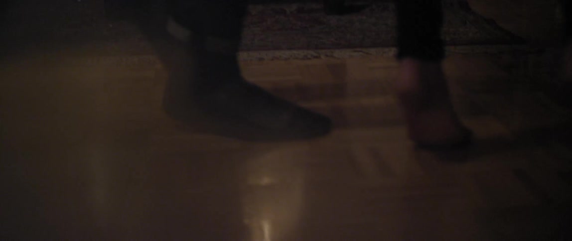 A young adult couple dancing with one of them being barefoot
