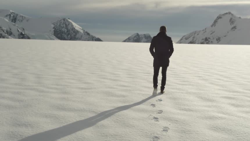 Man walking in the snow on a sunny day