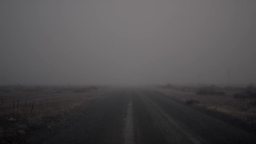 A foggy background as one rides down a road