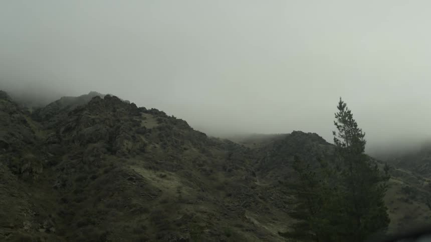 A hillside area underneath a fog filled sky