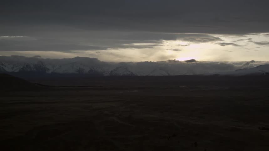 Field at sunset with mountains in the background