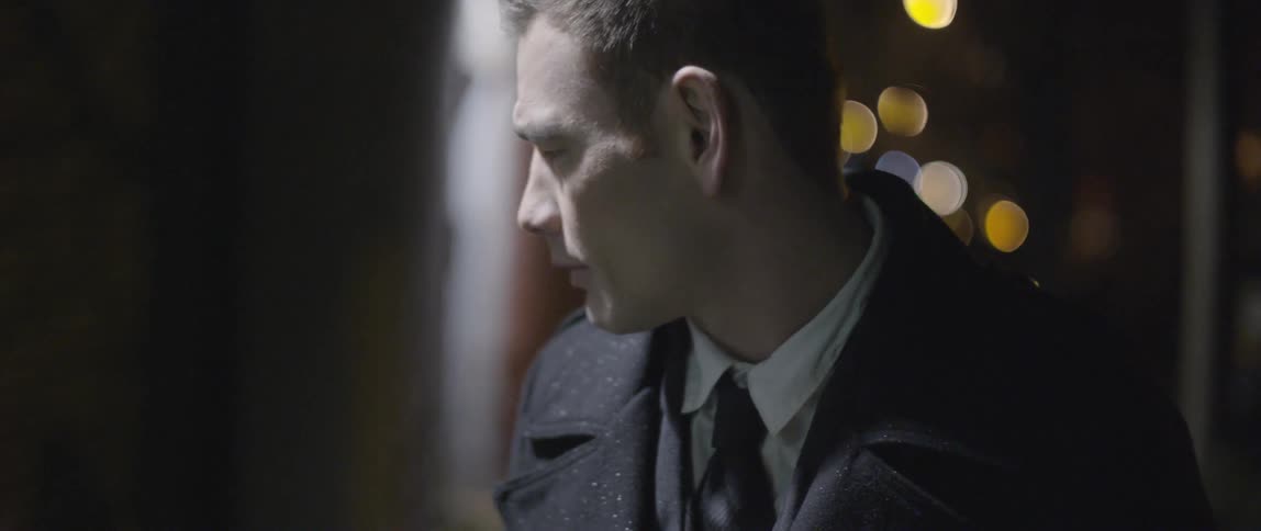 Sunlight shines down on a man in a coat