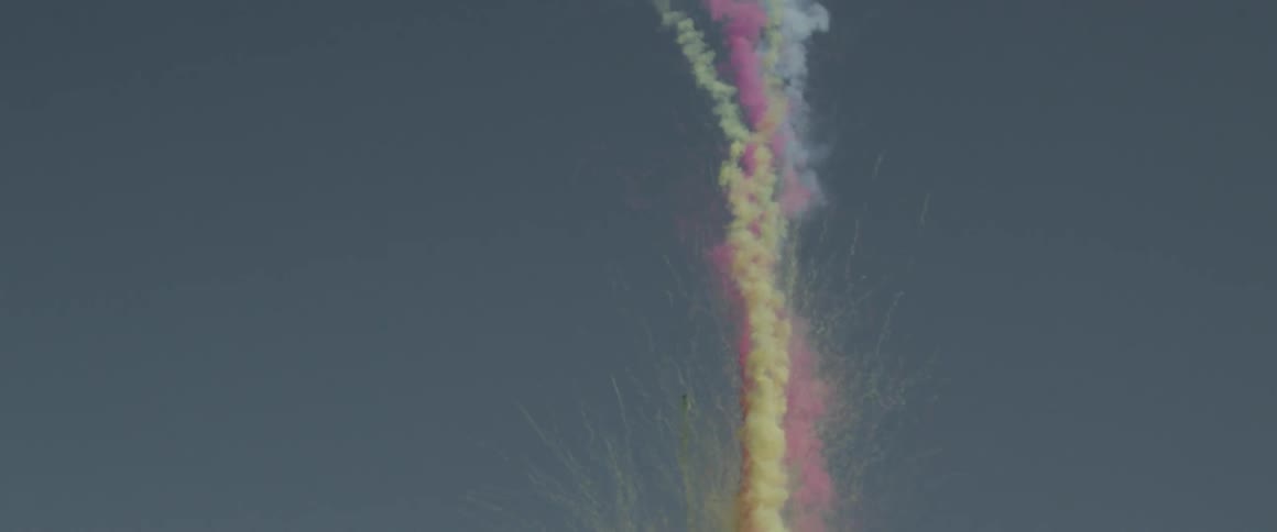 Purple colored smoke that launches in the sky, followed by yellow smoke