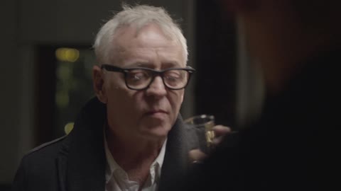 Two men talking at night time and having a drink