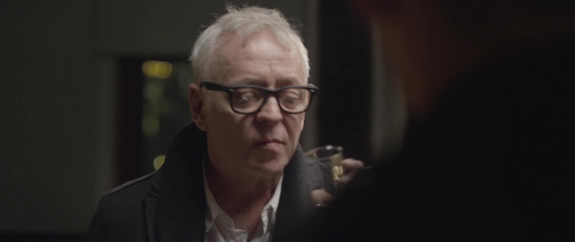Two men talking at night time and having a drink