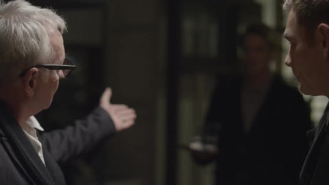 Two men have a conversation then take a shot together