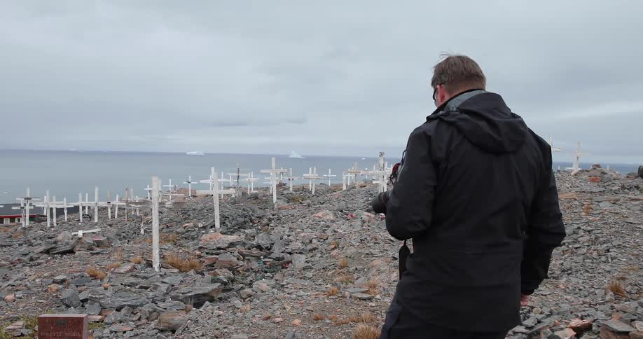 A man walks across a rocky graveyard