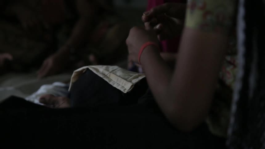 A woman uses scissors to cut string from fabric