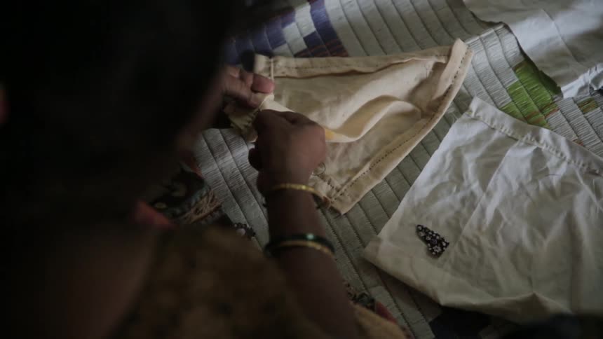 A person sowing some fabric together
