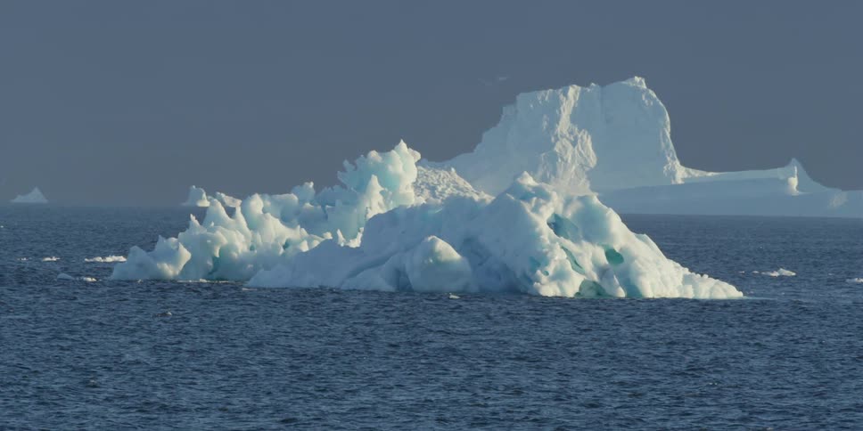 Icebergs in the sea as waves roll around them