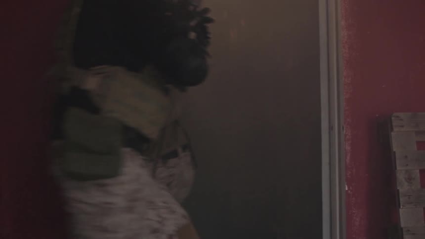 Three military men breaching a door and entering