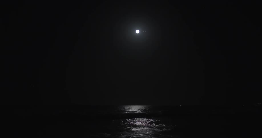 Light from a full moon shines on water below